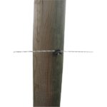 Izolator pribit na leseni količek za električno ograjo, z napeto žico